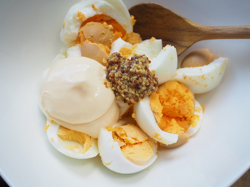 つぶしたゆで卵に、マヨネーズ、粒マスタード、塩を入れて全体をよく混ぜる。